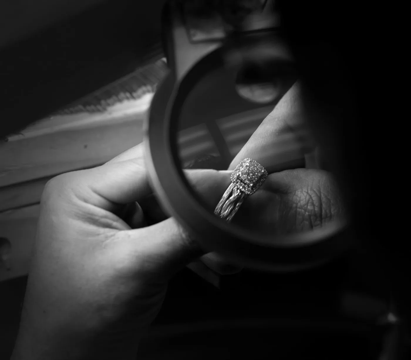 RJS jeweler inspecting a diamond ring through a loupe during quality control